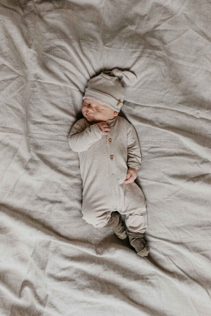 Baby trägt Strampler Nixnut Beige 1