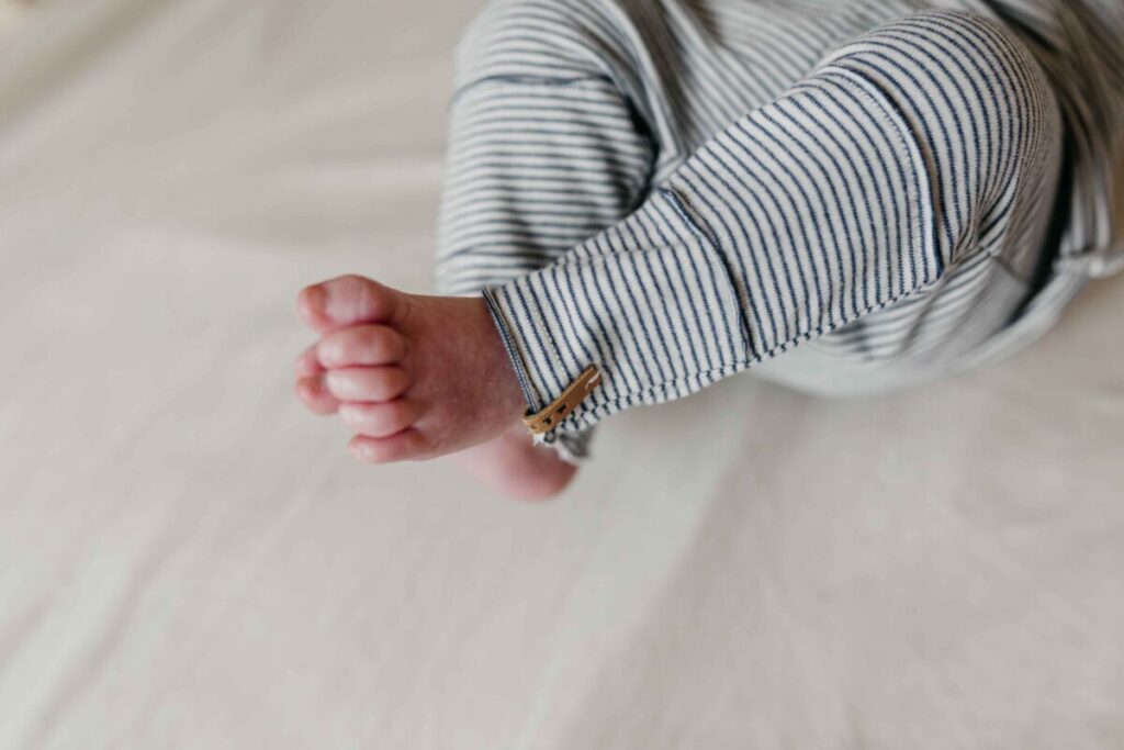 Baby trägt Hose Nixnut Grau gestreift 1