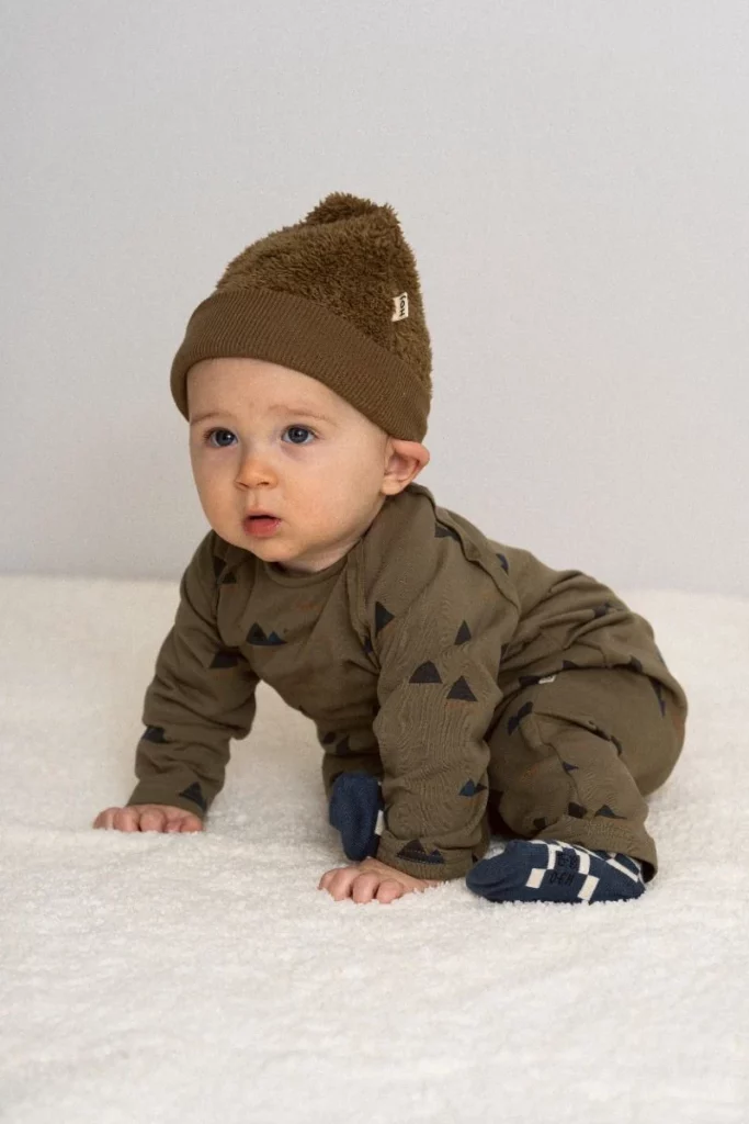 Baby trägt Strampler House of Jamie Grün